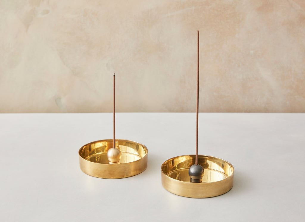 A charming modernist design, the brass sphere (available in natural brass or black patina ) sits upon a ring allowing you to pivot the incense in any direction.