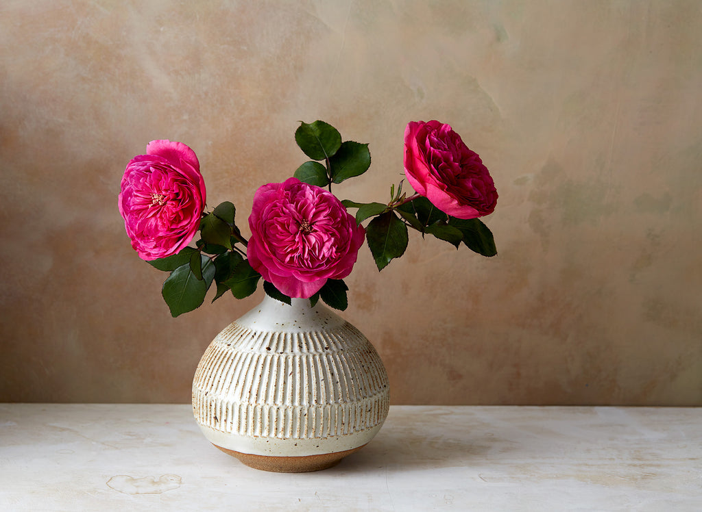 Beautiful hand thrown tulip vase with pinched neck, lipped opening and notches carved into the body. Glazed in white with brown speckles, from Mt. Washington Pottery.